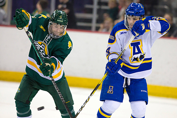 A UAA and UAF hockey player face off
